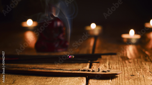 Burning incense stick. Buddha with incense sticks and candle on old wooden table.