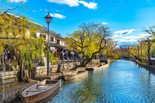 View of Kurashiki Bikan Historical Quarter. Townscape known for characteristically Japanese white walls of residences and willow trees lining banks of Kurashiki River, Okayama, Japan