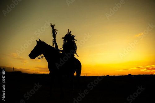 The Indians are riding a horse and spear ready to use In light of the Silhouette