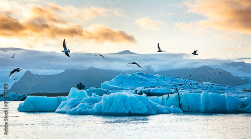 Travel concept. Beautiful sunset over the famous glacier lagoon Jokulsarlon, view of icebergs floating. Location: Jokulsarlon glacier lagoon, Iceland. Artistic picture. Beauty world.