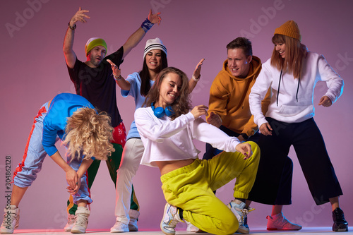 Extremely positive photo of joyful young dancers yelling with pleasure, showing different gestures, expressing happiness, spending time in modern dance studio