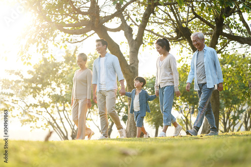 three generation asian family walking in park