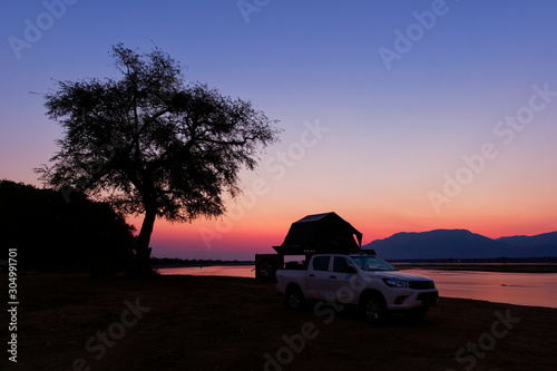 African safari in own cars with tents on the roof, sleeping on the riverside of Zambezi in Zimbabwe, star trails on the sky and night picture