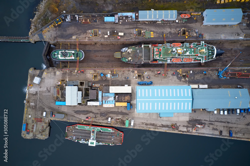 Dry dock and ship with shipbuilding in construction activity aerial view from above Greenock UK