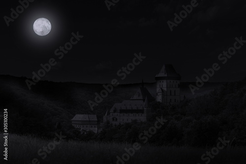 Spooky night over Karlstejn Castle. Full moon. Czech Republic.