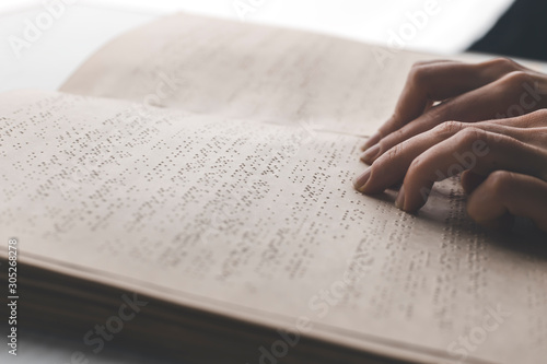 A blind man is reading a braille book. Disability concept.