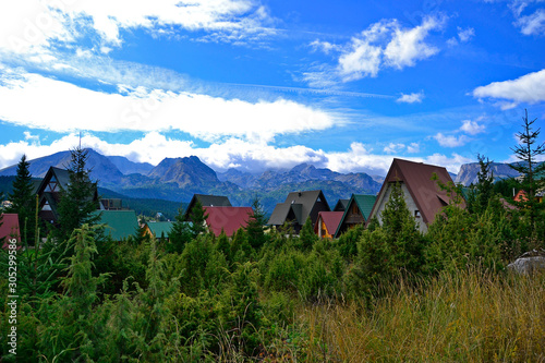 Colored roofs, trees and mountains.