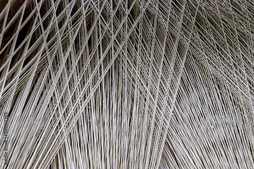 Close up of a lot of threads in a weaving machine called a loom