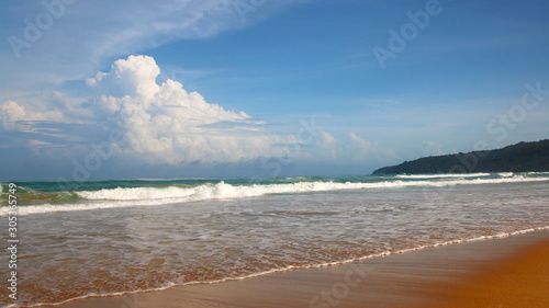 Waves, surf, and the blue sky over the sea, Karon sandy beach on a sunny day, Thailand