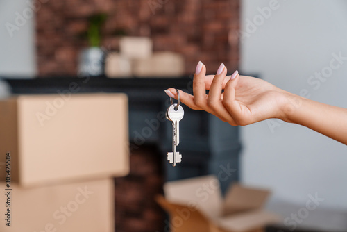 House key in womans hands, concept of moving or rent appartment