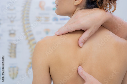 Young woman receiving shoulder massage in a physiotherapy center