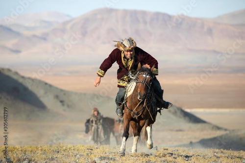Traditional Mongolian game where a rider on horseback aims to pick up a napkin from the ground at full speed gallop. Ulgii, Mongolia.