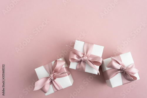 Gift boxes wiyh powdery ribbon. Powdery background. Silver bracelet with charms. Gift box for the New Year and Christmas. Best gift for Valentines Day and Mothers day.