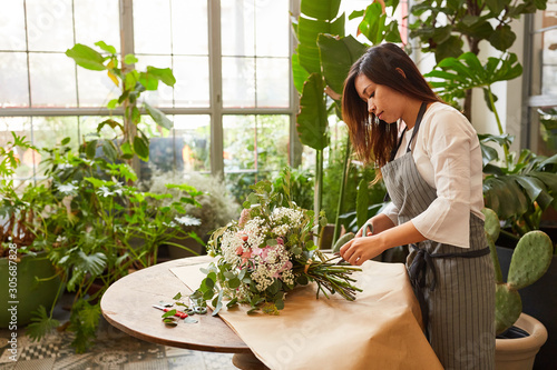 Floristin beim Blumenstrauß binden für den Versand