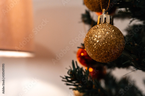 Bola dourada natalina pendurada na árvore de natal