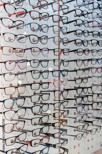 A large assortment of different glasses on a shelf in an optics store