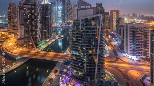 Aerial view of Dubai Marina residential and office skyscrapers with waterfront night to day timelapse