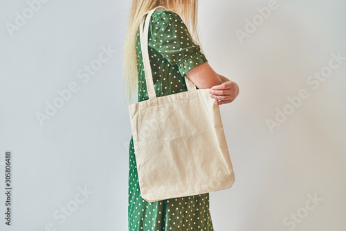 A Girl is holding blank cotton eco tote bag, design mockup.