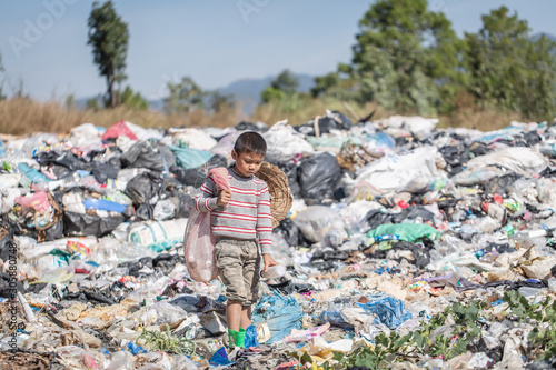 Poor boy collecting garbage in his sack to earn his livelihood, The concept of poor children and poverty