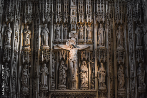 Jesus Christ on the cross in a cathedral or church interior surrounded by ornate stone carvings