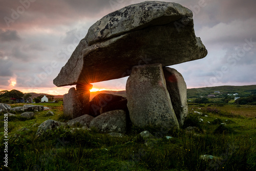 Sunset flare passing through Kilclooney More dolmen