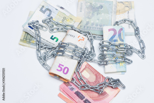 Dinero y cadenas, billetes de dinero rodeados de cadenas, metáfora de la vida en la que vivimos, encadenados o esclavos del dinero