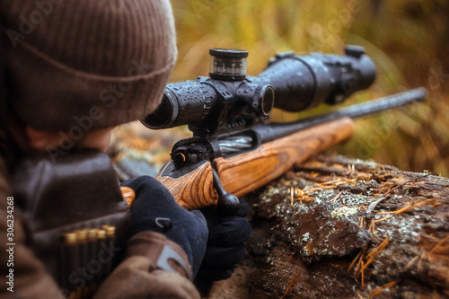 a rifle with a telescopic sight. hunting in the forest