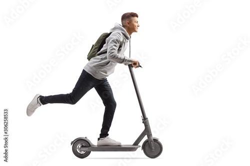 Male student with a backpack riding an electric scooter