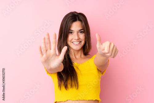 Teenager Brazilian girl over isolated pink background counting six with fingers