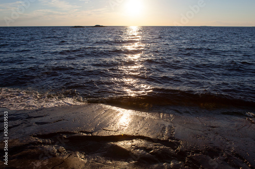 Rocky coast of Onega Lake at sunset in White Nights season - Republic of Karelia, Russia. Selective focus.