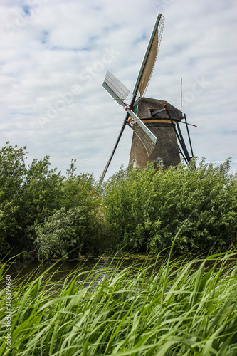 Historic Dutch windmill on the polders with some clouds, Kinderdijk, Netherlands