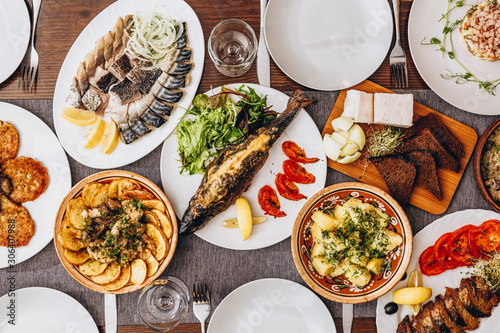 large wooden table with mouthwatering national Russian dishes. The restaurant where the food is cooked is as satisfying and delicious as home, top view