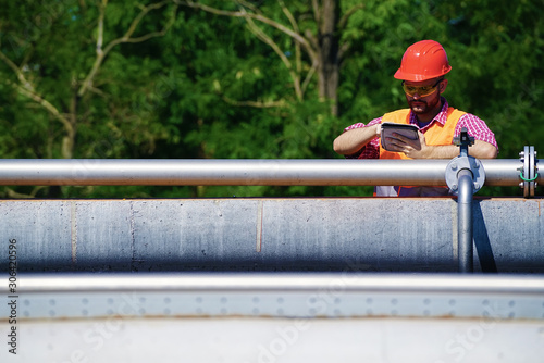 An engineer controlling a quality of water ,aerated activated sludge tank at a waste water treatment plant., pollution