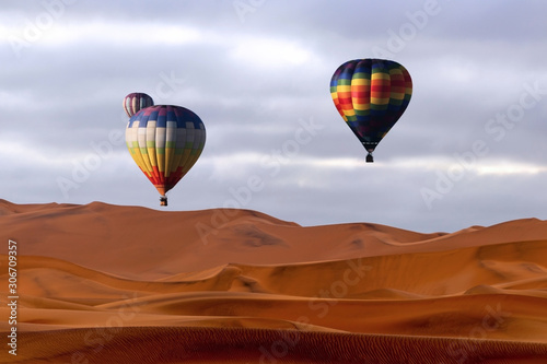 Beautiful Colorful Hot Air Balloons and dramatic clouds over the sand dunes in the Namib desert