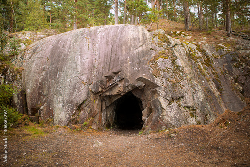 Black hole in rock wall, entrance to the cave in Spro, old mineral mine. Nesodden Norway. Nesoddtangen peninsula.