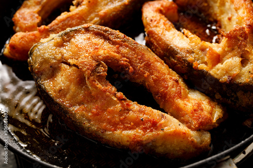 Carp, frying carp divided into portions, breaded in breadcrumbs and flour in a pan, close-up. Christmas Eve dish