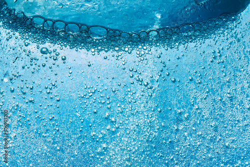 Sparkling Mineral Water Background. Blue bubbles of fresh soda float to the surface of drink to quench your thirst