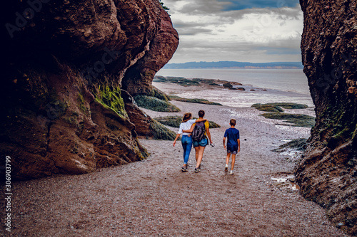 Familly people walking at Sunset in Hopewell Rocks at low tide