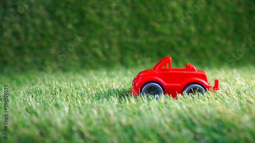 Toy car on the green artificial grass. Artificial turf background with copy space.