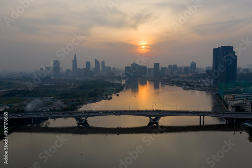 Saigon river sunset with extreme air pollution. Beautiful orange, red sky and reflections with Ho Chi Minh City, Vietnam Skyline.