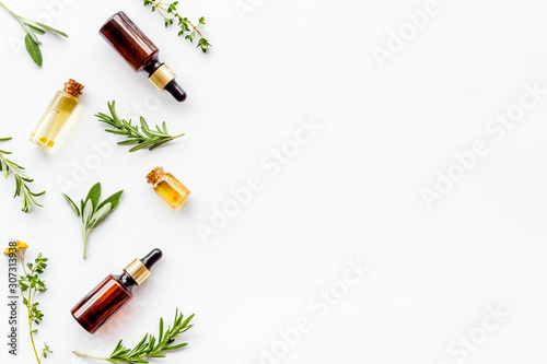 Essential oils and fresh herbs on white background top view pattern frame copy spacee
