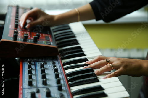 hands of a musician play a synthesizer