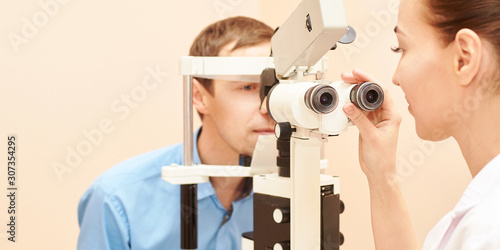 ophthalmologist doctor in exam optician laboratory with male patient. Men eye care medical diagnostic. Eyelid treatment