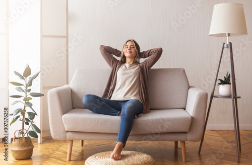 Millennial girl relaxing at home on couch, enjoying free time
