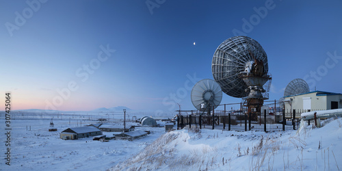 Winter panorama with large satellite dishes. Telecommunications in the Arctic. Industrial landscape with antennas. Morning twilight. Location place: Anadyr, Chukotka, Siberia, Far East of Russia.