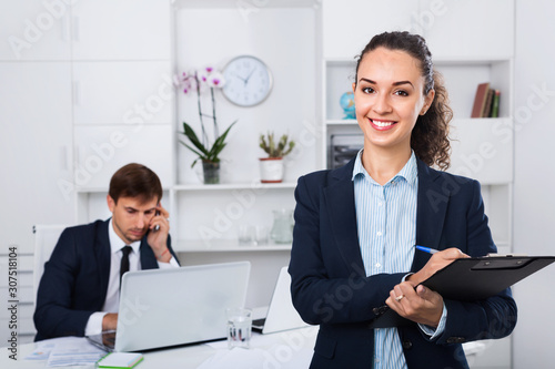 Glad business female secretary having cardboard in hands