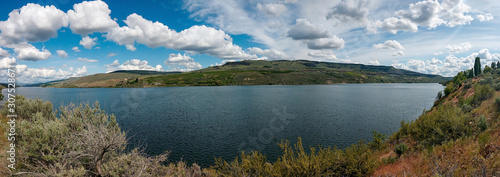 Panoramic view taken from Steamboat Rock State Park in Central Washington with blue skies and cumulus clouds over the Devil's Punch Bowl in springtime.