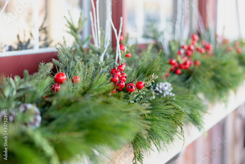 Window box decorated for the holidays with fresh greens and red berries