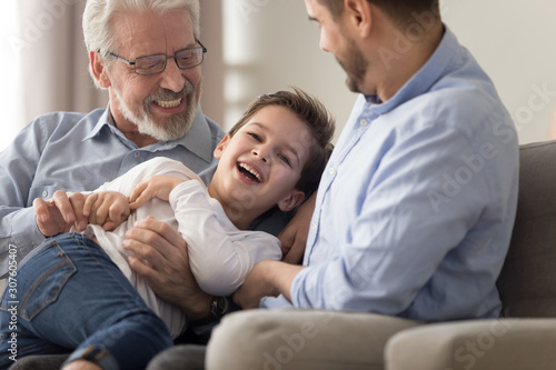 Cheerful grandfather son and grandson having fun at home