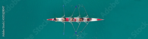 Aerial drone top panoramic view of sport canoe rowing synchronous athletes competing in tropical exotic lake